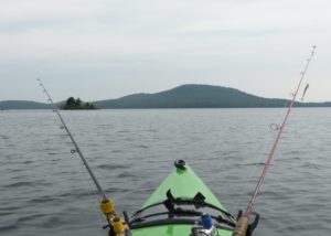 A first person POV of a kayak with kayak fishing pole holders on an Adirondack lake. 