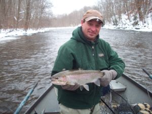 Fisherman poses on a boat in winter with his catch