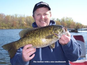 Angler posing with smallmouth, while early season bass fishing