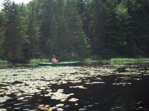 An adirondack kayak angler enjoying solitude in the lily pads.
