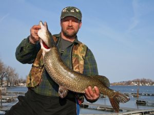 Angler poses with large pike caught while ice fishing on sodus bay