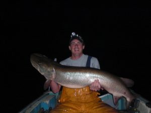 angler at night holding large musky