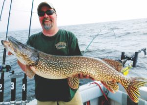 man on a boat holding a large northern pike